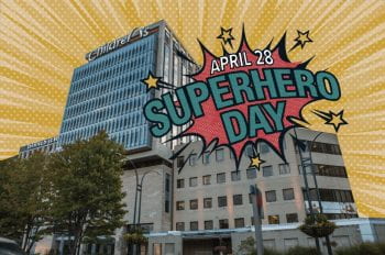 Picture of St. Louis Children's Hospital with comic book art skyline and text overlay that reads "April 28 Superhero Day."